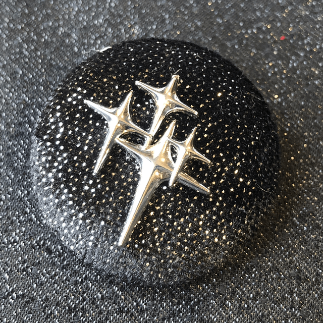 Broche noir paillettée avec ses étoiles atomiques